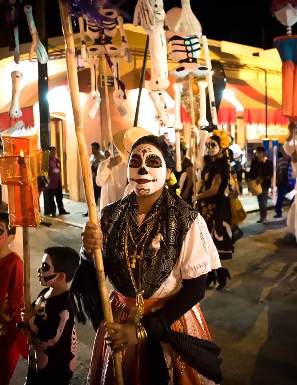 A person with traditional La Catrina face paint and a floral headdress